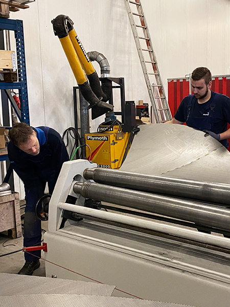 Twee monteurs aan het werk met de 3-rollen platenwals.